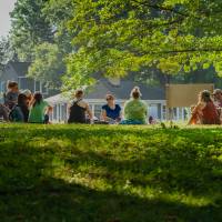 adults seated in a circle outside